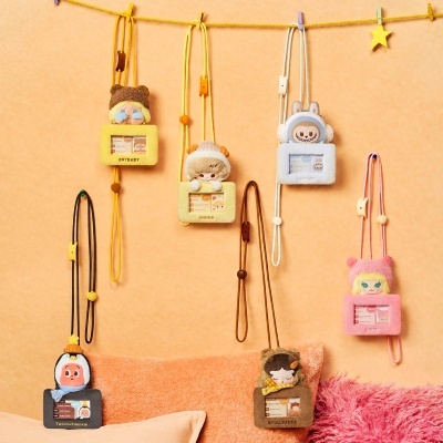 Bolsos de tecido peludo com peluches e alças pendurados numa corda amarela