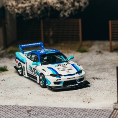 Carro de brinquedo Nissan de corrida branco e azul num cenário exterior