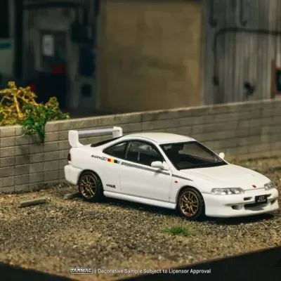 Miniatura de carro desportivo branco com jantes douradas estacionado em cascalho