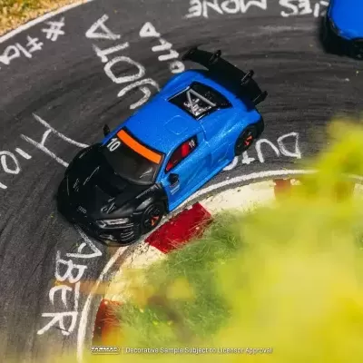 Carros de corrida azuis e pretos na pista curva com marcações brancas e vermelhas.