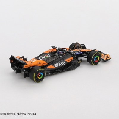Miniatura de carro de Fórmula 1 preto e laranja com pneus P ZERO e várias marcas visíveis