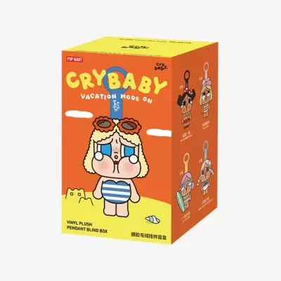Caixa laranja e amarela com desenho e texto de brinquedo surpresa CRYBABY VACATION MODE ON com boneco de vinil plush de verão.