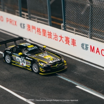 Carrinho de corrida de miniatura preto e amarelo numa pista de corrida com barreiras