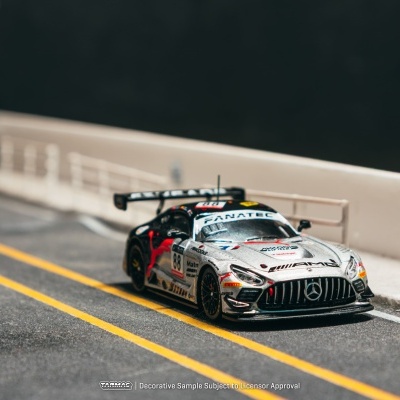 Miniatura de carro de corrida Mercedes AMG cinza e preto com detalhes vermelhos na pista de corrida.
