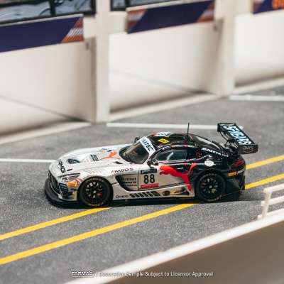 Modelo de carro de corrida preto e prata com número 88 numa pista em miniatura