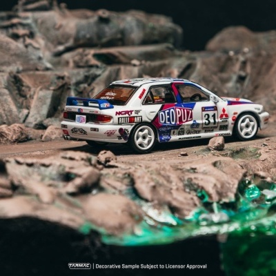 Carro de corrida de brinquedo branco com decalques coloridos num cenário rochoso