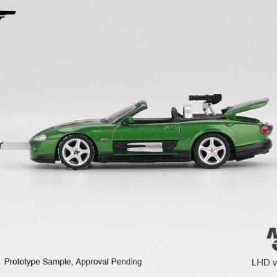 Miniatura de carro verde metálico conversível com arma e textos em branco.