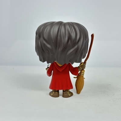 Figura colecionável de plástico com cabelo cinzento e vestido vermelho vista de trás