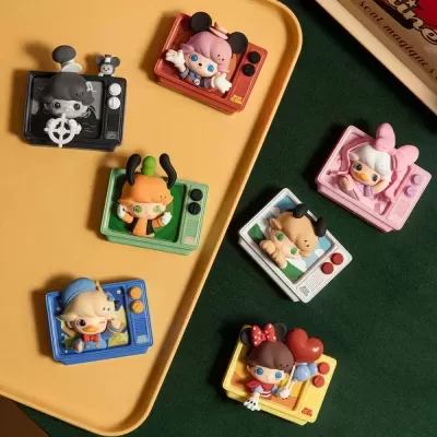 Brinquedos coloridos com figuras infantis em molduras de TVs retro em bandeja amarela