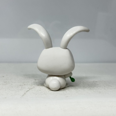 Figura branca de coelho de plástico vista de costas