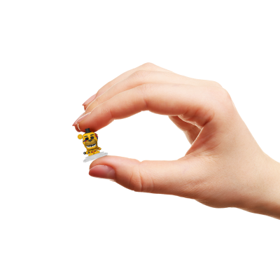 Miniatura amarela de boneco com chapéu preto a ser segurada por mão humana