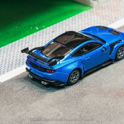 Miniatura de carro desportivo azul com detalhes pretos em maquete de rua