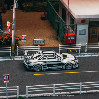 Miniatura de carro desportivo preto e branco numa rua em miniatura com sinais de trânsito e edifícios