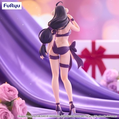 Figura colecionável de personagem feminina com lingerie roxa sobre tecido roxo e flores rosas