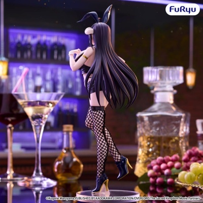 Estatueta feminina com orelhas de coelho e roupa preta em ambiente de bar