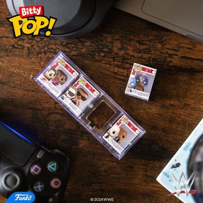 Conjunto de figuras Funko Pop! Bitty WWE numa mesa de madeira com comando de videojogo e portátil