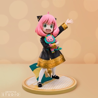 Figura colecionável de personagem feminina com cabelo rosa e vestido preto e dourado segurando brinquedo rosa
