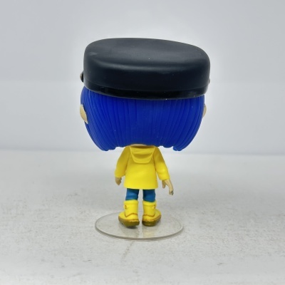 Figura colecionável vista de costas, cabelo azul, casaco amarelo e botas amarelas.