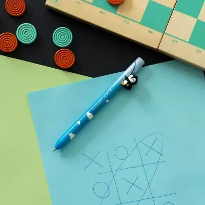 Caneta azul com pingüim decorativo em papel azul com desenho do jogo do galo e peças de jogo ao redor