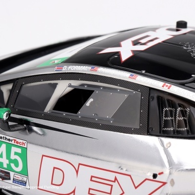 Carro de corrida modelo preto e prata com adesivos verdes, número 45 e textos dos pilotos