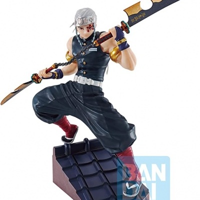 Estátua de personagem masculino segurando espada, posicionado sobre base de telhado escuro com logotipo BANDI