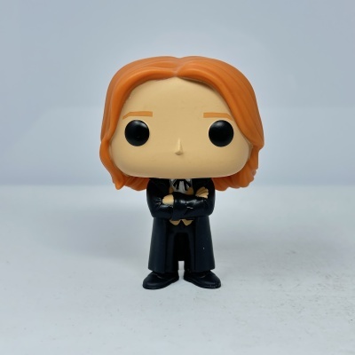 Funko Pop com cabelo laranja e roupa preta em fundo branco