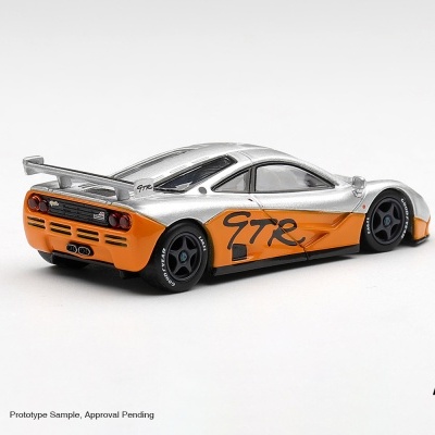 Miniatura de carro desportivo prateado e laranja com letras GTR e jantes pretas