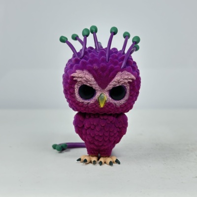 Figura colecionável roxa tipo coruja com detalhes verdes e rosa