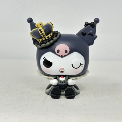 Figura plástica de personagem cinzenta com coroa amarela e laços pretos, rosto branco e olhos a piscar.