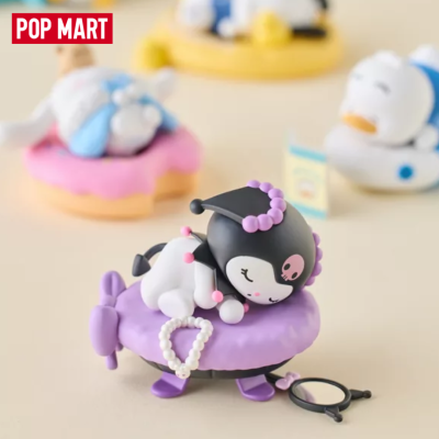 Figura de vinil de personagem a dormir sobre almofada roxa com espelho pequeno preto e colar de pérolas.