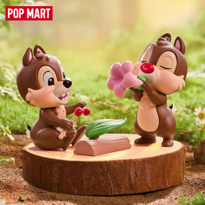 Duas figuras de esquilos castanhos a tocar instrumentos num tronco de madeira ao ar livre