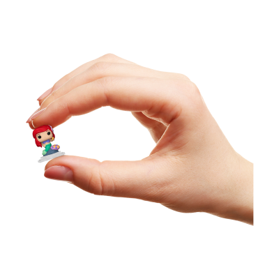 Miniatura de boneca com cabelo vermelho segurada por mão humana