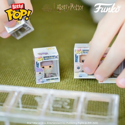 Miniaturas Funko Pop! Bitty Harry Potter em caixas pequenas sobre superfície verde