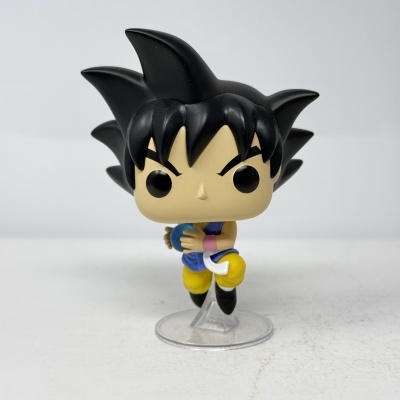 Figura Funko Pop de personagem com cabelo preto espetado e roupa azul e amarela segurando esfera azul