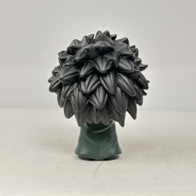Figura de coleção com cabelo preto espetado e capa verde.