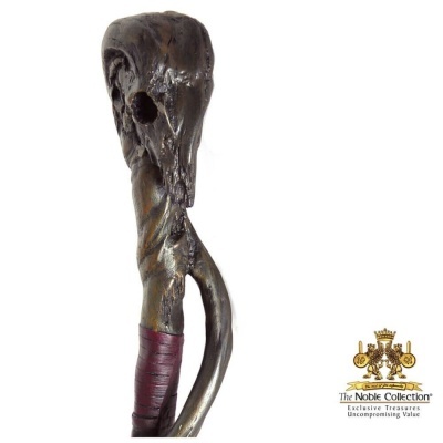 Cajado decorativo com cabeça de animal esculpida em madeira escura e texto The Noble Collection