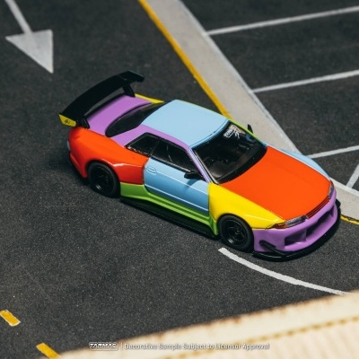 Modelo de carro colorido de brinquedo numa superfície simulando estacionamento.