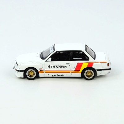 Miniatura de carro branco com detalhes vermelhos e amarelos e rodas douradas