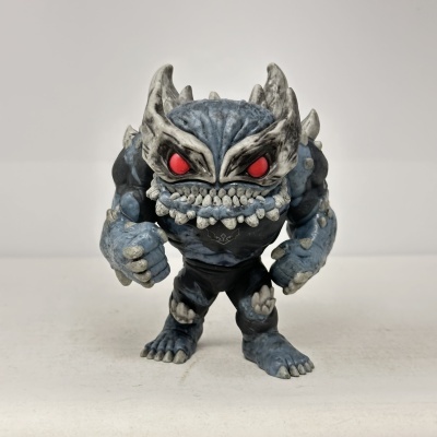 Figura de criatura monstruosa azul e cinza com olhos vermelhos e dentes brancos