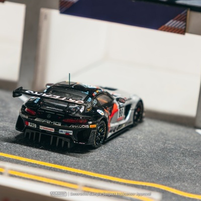 Modelo de carro de corrida preto com logotipos em pista de corrida em miniatura