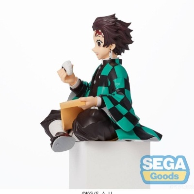 Figura colecionável do personagem Tanjiro Kamado sentado com casaco verde e preto quadriculado.
