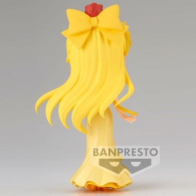 Figura de coleção com cabelo e vestido amarelos, grande laço no cabelo, fundo cinzento