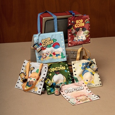 Sacolas coloridas com desenhos POPCORN e pequenos frascos pendurados sobre mala cinzenta e televisão antiga