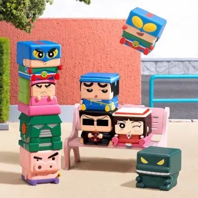 Bonecos de vinil quadrados coloridos empilhados e sentados num banco rosa ao ar livre