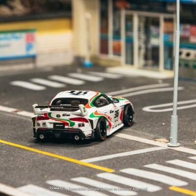Miniatura de carro de corrida branco com detalhes coloridos numa miniatura de rua