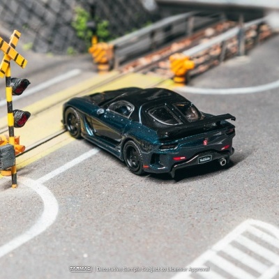Miniatura carro desportivo preto numa estrada com sinais de passagem de nível