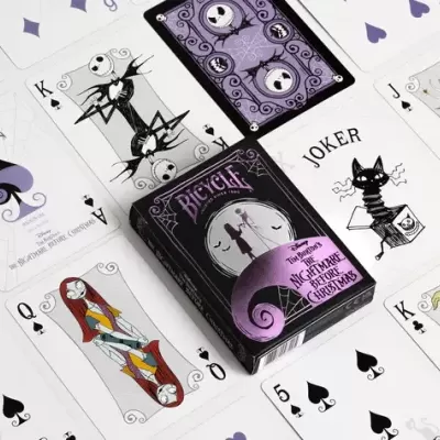 Baralho temático The Nightmare Before Christmas da Bicycle com cartas coloridas e a preto e branco dispostas à volta da caixa.