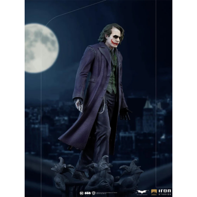 Figura do Joker com casaco roxo em base com gárgulas à noite