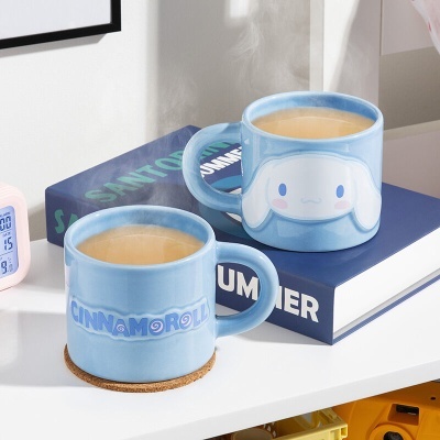 Duas canecas azuis com design Cinnamoroll numa mesa branca com livro azul e despertador rosa
