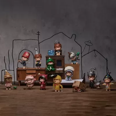 Figuras de crianças em roupas coloridas e fantasias em frente a móveis e parede cinzenta com desenhos.